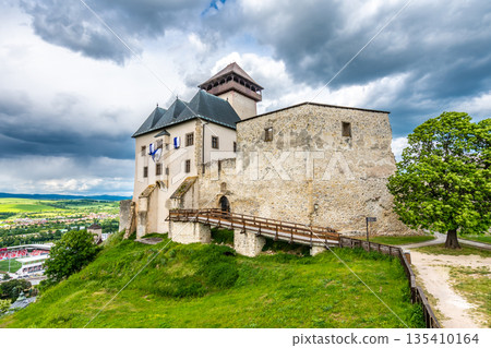 Ancient castle Trencin, Slovakia. Old fort on the hill, big walls and towers. Summer day, dramatic clouds before storm. 135410164