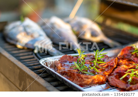 Sea bream dorado fish placed on the grill. Fresh sea food with herb and lemon. Summer bbq 135410177