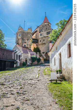 Outdoor view of Pernstejn castle near the Nedvedice village, Czech Republic. Fairytale castle on hill during summer day. Big stone walls and towers. 135410235