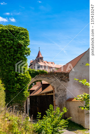 Outdoor view of Pernstejn castle near the Nedvedice village, Czech Republic. Fairytale castle on hill during summer day. Big stone walls and towers. Outdoor view of Pernstejn castle near the Nedvedice village, Czech Republic. Fairytale castle on hill during summer day. Big stone walls and towers. 135410247