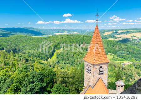 Famous medieval castle Bouzov, Czech Republic. National landmark built in 14 century. Famous tourist destination. Summer weather, blue sky. Famous medieval castle Bouzov, Czech Republic. National landmark built in 14 century. Famous tourist destination. Summer weather, blue sky. 135410282