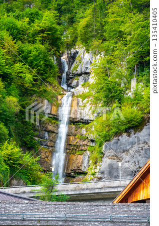 Waterfall at Hallstat city, Austria. Fresh water stream above city roofs. Waterfall at Hallstat city, Austria. Fresh water stream above city roofs. 135410405