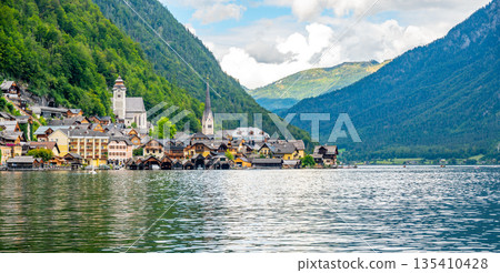 Famous Hallstatt city panorama with typical church near the Hallstatter see. Dramatic clouds on the sky. Famous tourist destination in Austria. Famous Hallstatt city panorama with typical church near the Hallstatter see. Dramatic clouds on the sky. Famous tourist destination in Austria. 135410428