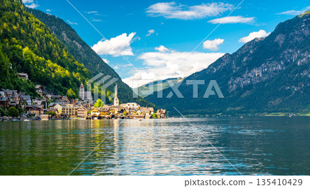 Famous Hallstatt city panorama with typical church near the Hallstatter see. Dramatic clouds on the sky. Famous tourist destination in Austria. Famous Hallstatt city panorama with typical church near the Hallstatter see. Dramatic clouds on the sky. Famous tourist destination in Austria. 135410429
