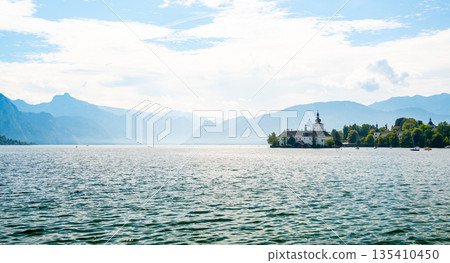 Schloss Ort castle near Traunsee, Austria. View of ancient castle with long bridge over lake. Famous tourist destination. Schloss Ort castle near Traunsee, Austria. View of ancient castle with long bridge over lake. Famous tourist destination. 135410450