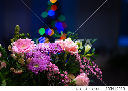 Bunch of gerbera flowers placed in front of christmas tree Bunch of gerbera flowers placed in front of christmas tree 135410613