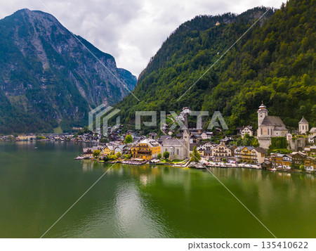 Aerial view of austrian mountain village Hallstatt and Hallstatter lake. Beautiful summer time. Salzkammergut, Austria. Hallstatt village over Hallstatter See, in Salzkammergut, Austria. Aerial view of austrian mountain village Hallstatt and Hallstatter lake. Beautiful summer time. Salzkammergut, Austria. Hallstatt village over Hallstatter See, in Salzkammergut, Austria. 135410622
