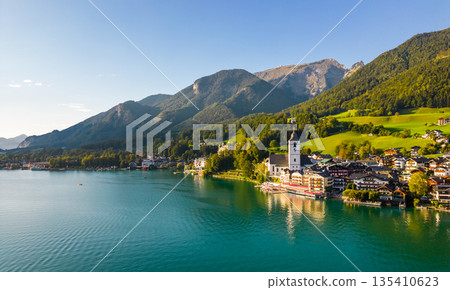 Beautiful aerial view of the popular village of Sankt Wolfgang im Salzkammergut. Alpine mountains, church and Wolfgangsee. Upper Austria, Salzburg. Beautiful aerial view of the popular village of Sankt Wolfgang im Salzkammergut. Alpine mountains, church and Wolfgangsee. Upper Austria, Salzburg. 135410623