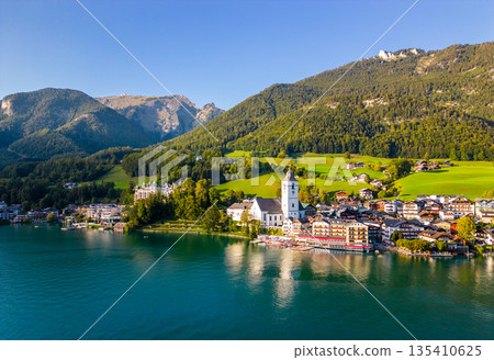 Beautiful aerial view of the popular village of Sankt Wolfgang im Salzkammergut. Alpine mountains, church and Wolfgangsee. Upper Austria, Salzburg. Beautiful aerial view of the popular village of Sankt Wolfgang im Salzkammergut. Alpine mountains, church and Wolfgangsee. Upper Austria, Salzburg. 135410625