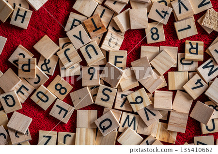 Black letters placed on wood. Small pieces of alphabet. 135410662