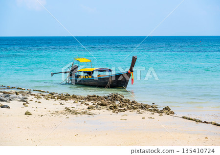 Long tailed boats near tropical beach at Ko Phi Phi, Thailand. Tropic beach with white sand and turquoise water, concept of vacation in paradise. 135410724