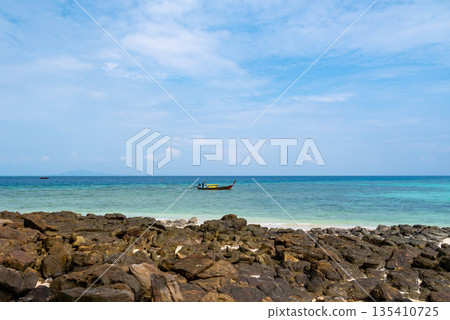 Long tailed boats near tropical beach at Ko Phi Phi, Thailand. Tropic beach with white sand and turquoise water, concept of vacation in paradise. Long tailed boats near tropical beach at Ko Phi Phi, Thailand. Tropic beach with white sand and turquoise water, concept of vacation in paradise. 135410725