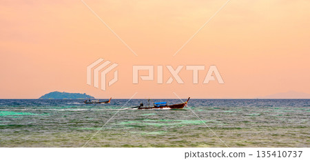 Long tailed boats near tropical beach at Ko Phi Phi, Thailand. Tropic beach with white sand and turquoise water, concept of vacation in paradise. Long tailed boats near tropical beach at Ko Phi Phi, Thailand. Tropic beach with white sand and turquoise water, concept of vacation in paradise. 135410737