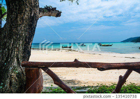 Long tailed boats near tropical beach at Ko Phi Phi, Thailand. Tropic beach with white sand and turquoise water, concept of vacation in paradise. 135410738
