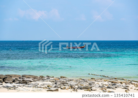 Long tailed boats near tropical beach at Ko Phi Phi, Thailand. Tropic beach with white sand and turquoise water, concept of vacation in paradise. Long tailed boats near tropical beach at Ko Phi Phi, Thailand. Tropic beach with white sand and turquoise water, concept of vacation in paradise. 135410741