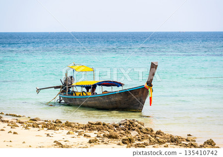 Long tailed boats near tropical beach at Ko Phi Phi, Thailand. Tropic beach with white sand and turquoise water, concept of vacation in paradise. 135410742