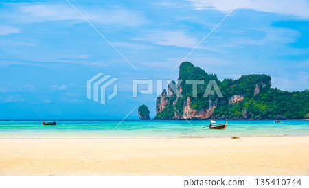 Landscape view of coastline with limestone rock and boats on ocean at Ko Phi Phi islands, Thailand. Concept of exotic tropical vacation and beautiful nature in paradise Landscape view of coastline with limestone rock and boats on ocean at Ko Phi Phi islands, Thailand. Concept of exotic tropical vacation and beautiful nature in paradise 135410744