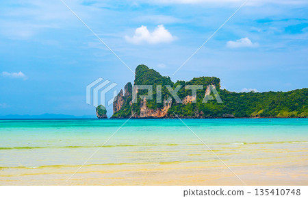 Landscape view of coastline with limestone rock and boats on ocean at Ko Phi Phi islands, Thailand. Concept of exotic tropical vacation and beautiful nature in paradise 135410748