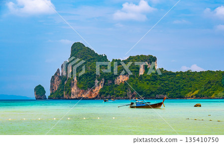 Landscape view of coastline with limestone rock and boats on ocean at Ko Phi Phi islands, Thailand. Concept of exotic tropical vacation and beautiful nature in paradise 135410750