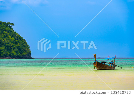 Landscape view of coastline with limestone rock and boats on ocean at Ko Phi Phi islands, Thailand. Concept of exotic tropical vacation and beautiful nature in paradise 135410753