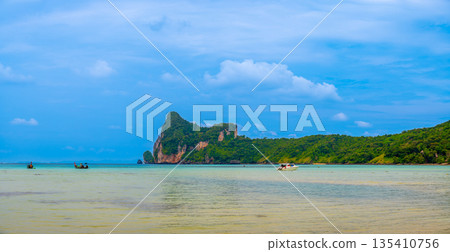 Landscape view of coastline with limestone rock and boats on ocean at Ko Phi Phi islands, Thailand. Concept of exotic tropical vacation and beautiful nature in paradise 135410756