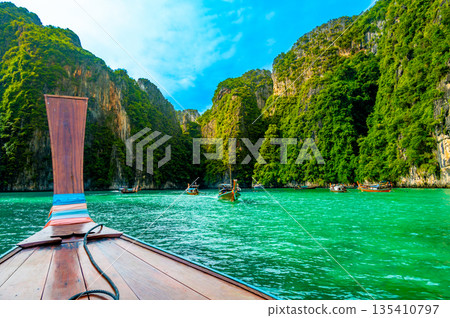 View of Pi Leh lagoon (also known as Green Lagoon) at Ko Phi Phi islands, Thailand. View from typical long tailed boat. Typical Thai picture of tropical paradise. Limestone rock and turquoise water. 135410797