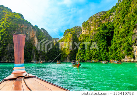 View of Pi Leh lagoon (also known as Green Lagoon) at Ko Phi Phi islands, Thailand. View from typical long tailed boat. Typical Thai picture of tropical paradise. Limestone rock and turquoise water. 135410798
