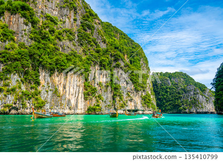 View of Pi Leh lagoon (also known as Green Lagoon) at Ko Phi Phi islands, Thailand. View from typical long tailed boat. Typical Thai picture of tropical paradise. Limestone rock and turquoise water. 135410799