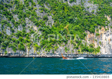 View of limestone rock at Ko Phi Phi islands, Thailand. View from long tailed boat. Exotic and tropic nature, summer paradise. View of limestone rock at Ko Phi Phi islands, Thailand. View from long tailed boat. Exotic and tropic nature, summer paradise. 135410803