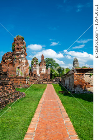 Ruins of ancient city and temples Ayutthaya, Thailand. Old kingdom of Siam. Summer day with blue sky. Famous tourist destination, spiritual place near Bangkok. 135410811
