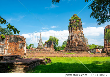 Ruins of ancient city and temples Ayutthaya, Thailand. Old kingdom of Siam. Summer day with blue sky. Famous tourist destination, spiritual place near Bangkok. Ruins of ancient city and temples Ayutthaya, Thailand. Old kingdom of Siam. Summer day with blue sky. Famous tourist destination, spiritual place near Bangkok. 135410817