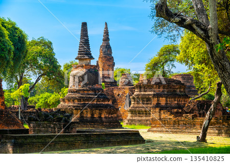 Ruins of ancient city and temples Ayutthaya, Thailand. Old kingdom of Siam. Summer day with blue sky. Famous tourist destination, spiritual place near Bangkok. Ruins of ancient city and temples Ayutthaya, Thailand. Old kingdom of Siam. Summer day with blue sky. Famous tourist destination, spiritual place near Bangkok. 135410825