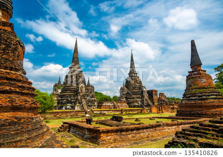Ruins of ancient city and temples Ayutthaya, Thailand. Old kingdom of Siam. Summer day with blue sky. Famous tourist destination, spiritual place near Bangkok. 135410826