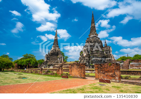 Ruins of ancient city and temples Ayutthaya, Thailand. Old kingdom of Siam. Summer day with blue sky. Famous tourist destination, spiritual place near Bangkok. 135410830