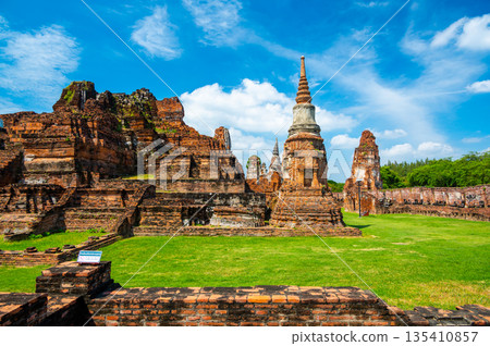 Ruins of ancient city and temples Ayutthaya, Thailand. Old kingdom of Siam. Summer day with blue sky. Famous tourist destination, spiritual place near Bangkok. 135410857