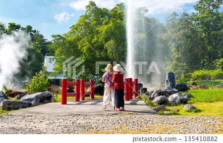 Two unidentifiable people are standing in front of hot spring at San Kamphaeng springs, Thailand. Two unidentifiable people are standing in front of hot spring at San Kamphaeng springs, Thailand. 135410882