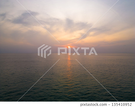 Sunset over the sea water. Soft warm colors and gentle clouds. Sunset over the sea water. Soft warm colors and gentle clouds. 135410952