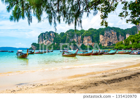 Long tail boats at Railay beach, Krabi, Thailand. Tropical paradise, turquoise water and white sand. Long tail boats at Railay beach, Krabi, Thailand. Tropical paradise, turquoise water and white sand. 135410970