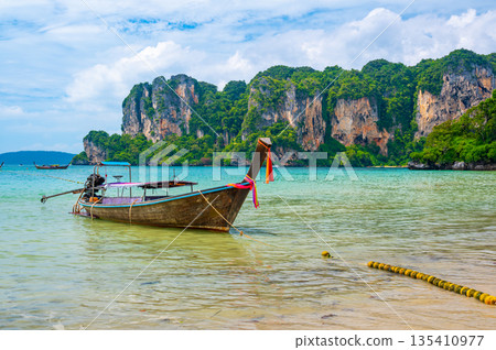 Long tail boats at Railay beach, Krabi, Thailand. Tropical paradise, turquoise water and white sand. Long tail boats at Railay beach, Krabi, Thailand. Tropical paradise, turquoise water and white sand. 135410977