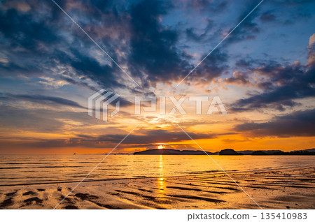 Beautiful sunset with dramatic clouds and sky of blue and orange color. Ao Nang beach, Krabi town, Thailand. Beautiful sunset with dramatic clouds and sky of blue and orange color. Ao Nang beach, Krabi town, Thailand. 135410983