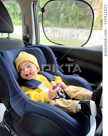 Smiling Baby in Car Seat with Yellow Sweater and Hat Smiling Baby in Car Seat with Yellow Sweater and Hat 135411021