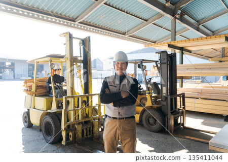 Male worker standing in front of a forklift Male worker standing in front of a forklift 135411044