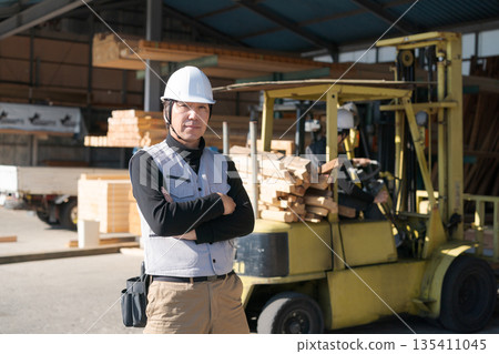 Male worker standing in front of a forklift Male worker standing in front of a forklift 135411045