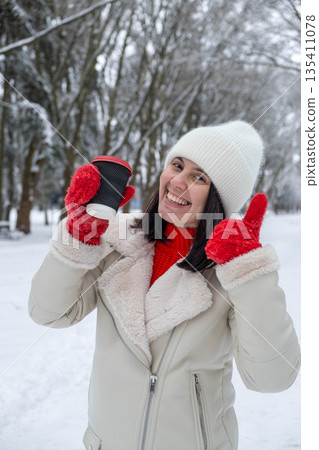 Woman Enjoying Coffee in Snowy Winter Park Woman Enjoying Coffee in Snowy Winter Park 135411078
