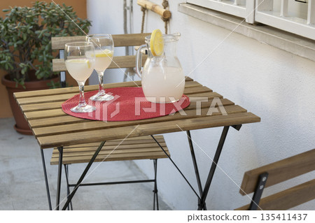 fresh lemonade in pitcher with glasses on an outdoor patio table fresh lemonade in pitcher with glasses on an outdoor patio table 135411437
