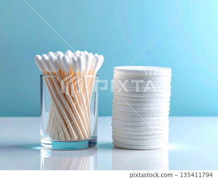 Cleaning ear. White cotton swabs and reusable cotton pads neatly stacked on a white background. 135411794