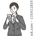 Illustration of a woman in a suit using a smartphone 135411859