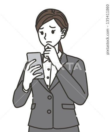 A woman in a suit thinking while looking at her smartphone A woman in a suit thinking while looking at her smartphone 135411860