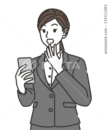 A woman in a suit surprised at her smartphone 135411861
