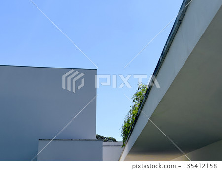 Modern minimalist architecture with clean lines and geometric shapes, contrasted against a bright Modern minimalist architecture with clean lines and geometric shapes, contrasted against a bright 135412158